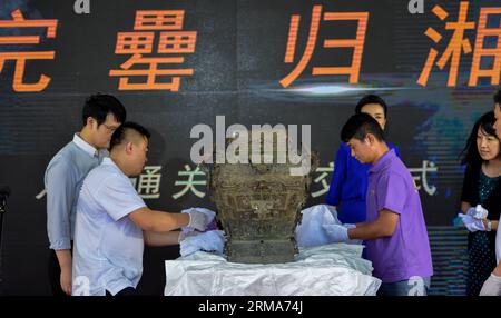 (140621) -- CHANGSHA, 21. Juni 2014 (Xinhua) -- Mitarbeiter packen die Min Fanglei am Flughafen von Changsha, der Hauptstadt der zentralchinesischen Provinz Hunan, am 21. Juni 2014 um. Lei war eine Art Ritualgefäß und Weinbehälter in der späten Shang-Dynastie (1600 v. Chr. bis 1046 v. Chr.) und frühen Zhou-Dynastie (1046 v. Chr. bis 771 v. Chr.) in China. Die Min Fanglei, die ihren Namen Min durch die Inschriften auf ihr erhielt, ist die exquisiteste und größte je gefundene Lei. Die Leiche von Min Fanglei wurde seit ihrer Entdeckung im Jahr 1919 im Taoyuan County of Hunan von ihrem Deckel getrennt. Die berühmte Bronzeware, die weg war Stockfoto