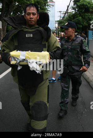 (140622) -- QUEZON CITY, 22. Juni 2014 (Xinhua) -- Ein Personal der Bombentruppe der philippinischen Nationalpolizei (PNP), das einen Bombenanzug trägt, hält ein verdächtiges Paket während einer Bombendrohung im PNP-Hauptquartier in Quezon City, Philippinen, am 22. Juni 2014. Die Bombendrohung stellte sich als negativ heraus, nachdem die Polizei Papiere in der Kiste gefunden hatte. (Xinhua/Rouelle Umali)(ctt) PHILIPPINEN-QUEZON CITY-BOMBENDROHUNG PUBLICATIONxNOTxINxCHN Quezon City 22. Juni 2014 XINHUA ein Personal der Bombentruppe der philippinischen National Police PNP, das einen Bombenanzug trägt, hält während der Fahrt ein Verdächtiges Paket Stockfoto