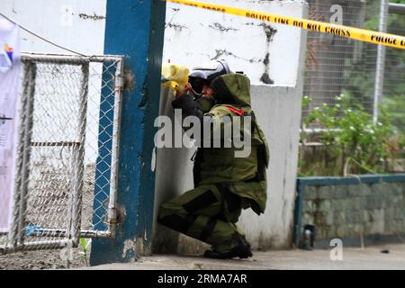 Ein Personal der Bombentruppe der philippinischen Nationalpolizei (PNP), das einen Bombenanzug trägt, hält ein verdächtiges Paket während einer Bombendrohung im PNP-Hauptquartier in Quezon City, Philippinen, am 22. Juni 2014. Die Bombendrohung stellte sich als negativ heraus, nachdem die Polizei Papiere in der Kiste gefunden hatte. (Xinhua/Rouelle Umali)(ctt) PHILIPPINEN-QUEZON CITY-BOMBENDROHUNG PUBLICATIONxNOTxINxCHN ein Personal der Bombentruppe der philippinischen Nationalpolizei PNP in einem Bombenanzug hält ein verdächtiges Paket während einer Bombendrohung im PNP-Hauptquartier in Quezon City auf den Philippinen AM Juni Stockfoto