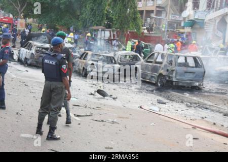 Sicherheitshelfer stehen am 25. Juni 2014 am Ort einer Bombenexplosion im zentralen Geschäftsviertel in der nigerianischen Hauptstadt Abuja wachsam. Mindestens 19 Menschen wurden bei einem Bombenanschlag getötet und 52 weitere verletzt, der am Mittwoch das Gebiet von Abuja in Wuse erschütterte. (Xinhua/Olatunji Obasa) NIGERIA-ABUJA-EXPLOSION-CASUALTY PUBLICATIONxNOTxINxCHN Security Stand Guard AM Ort einer Bombenexplosion im zentralen Geschäftsgebiet der nigerianischen Hauptstadt Abuja AM 25 2014. Juni wurden mindestens 19 Prominente GETÖTET und 52 weitere verletzt bei einem Bombenangriff Thatcher erschütterte das Gebiet Wuse in Abuja AM Mittwoch, XINHU Stockfoto