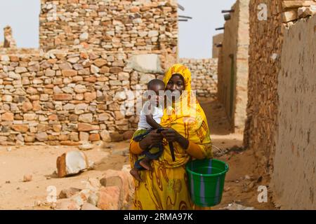 Eine Frau spaziert mit ihrem Baby in der antiken Stadt Ouadane in der Region Adrar, Mauretanien, 24. Juni 2014. (Xinhua/Li Jing)(lyi) MAURETANIEN-ADRAR-CHINGUETTI-DAILY Life PUBLICATIONxNOTxINxCHN eine Frau spaziert mit ihrem Baby IN DER antiken Stadt IN DER Region Adrar MAURETANIEN 24. Juni 2014 XINHUA verließ Jing lyi MAURETANIEN Adrar Daily Life PUBLICATIONxNOTxINxCHN Stockfoto