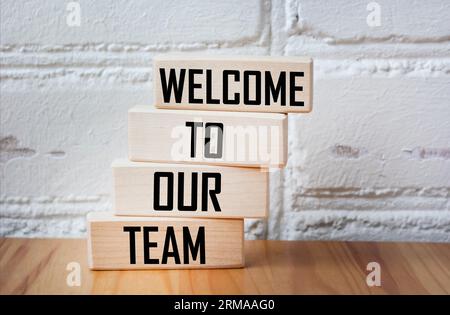 Begriffliche Worte Willkommen in unserem Team auf Holzblöcken. Wunderschöner Vintage-Hintergrund. Stockfoto
