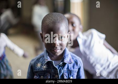 NAIROBI, June 29, 2014 -- A student reacts in a boxing school inside a building in Korogocho slum, Nairobi, capital of Kenya, June 29, 2014. The boxing school, with more than a hundred students aged from 4 to 20, is set up by NGO Fight for Peace. The school uses boxing and martial arts combined with education to realise the potential of young people and keeps them away from crimes and violence. Currently, there are dozens of such boxing schools in the slums in Nairobi, founded by different organizations. (Xinhua/Zhou Xiaoxiong) (dzl) KENYA-NAIROBI-SLUMS-BOXING SCHOOL PUBLICATIONxNOTxINxCHN   N Stock Photo