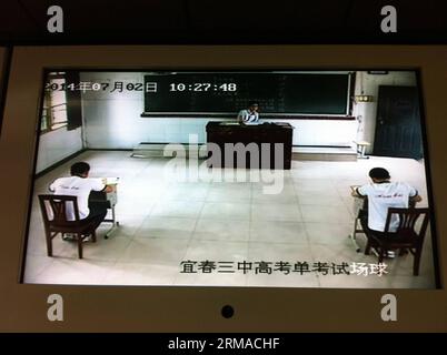 (140702) -- YICHUN, July 2, 2014 (Xinhua) -- Real-time monitoring screen shows an exclusive college entrance exam taken by Liu Yanbing and Yi Zhengyong in Yichun, east China s Jiangxi Province, July 2, 2014. Liu Yanbing and Yi Zhengyong, both from No.3 Middle School in Yichun, were seriously injured during a fight against an assailant who was stabbing passengers on a bus on May 31. They were unable to take the national college entrance exam, on June 7 and 8 as they were still recovering from their injuries. It is the first time Jiangxi s educational authority has organized a separate test for Stock Photo