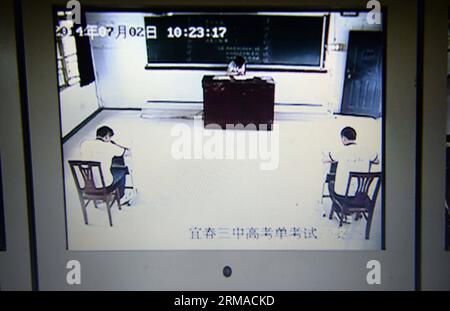 (140702) -- YICHUN, July 2, 2014 (Xinhua) -- Real-time monitoring screen shows an exclusive college entrance exam taken by Liu Yanbing and Yi Zhengyong in Yichun, east China s Jiangxi Province, July 2, 2014. Liu Yanbing and Yi Zhengyong, both from No.3 Middle School in Yichun, were seriously injured during a fight against an assailant who was stabbing passengers on a bus on May 31. They were unable to take the national college entrance exam, on June 7 and 8 as they were still recovering from their injuries. It is the first time Jiangxi s educational authority has organized a separate test for Stock Photo