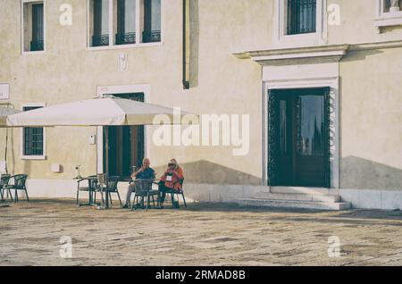 Venedig, Italien - Mai 30 2023: Seniorenpaar in einem Restaurant-Café in Venedig. Malerische idyllische Szene Stockfoto