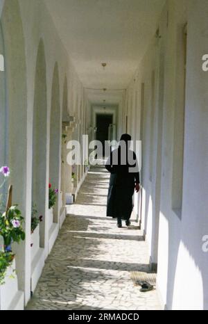 Galati County, Rumänien, 1999. Nonne, die auf dem Flur vor den Klosterzellen des Klosters Vladimiresti spaziert. Stockfoto