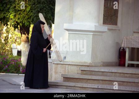 Galati County, Rumänien, 1999. Nonne spielt das Semantron im Kloster Vladimiresti. Stockfoto