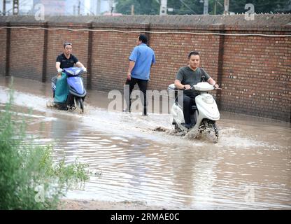 (140704) -- TAIYUAN, July 4, 2014 (Xinhua) -- Pedestrians and motorcyclists travel on a flooded street in Taiyuan, capital of north China s Shanxi Province, July 4, 2014. Rainstorms hit the city on Friday, flooding streets and causing traffic interruptions. (Xinhua/Yan Yan) (mp) CHINA-SHANXI-TAIYUAN-RAINSTORM-FLOODS (CN) PUBLICATIONxNOTxINxCHN   Taiyuan July 4 2014 XINHUA pedestrians and Motorcyclists Travel ON a flooded Street in Taiyuan Capital of North China S Shanxi Province July 4 2014 Rainstorm Hit The City ON Friday flooding Streets and causing Traffic interruptions XINHUA Yan Yan MP Ch Stockfoto