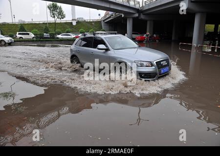 (140704) -- TAIYUAN, July 4, 2014 (Xinhua) -- A car moves on a flooded street in Taiyuan, capital of north China s Shanxi Province, July 4, 2014. Rainstorms hit the city on Friday, flooding streets and causing traffic interruptions. (Xinhua/Zhan Yan) (mp) CHINA-SHANXI-TAIYUAN-RAINSTORM-FLOODS (CN) PUBLICATIONxNOTxINxCHN   Taiyuan July 4 2014 XINHUA a Car Moves ON a flooded Street in Taiyuan Capital of North China S Shanxi Province July 4 2014 Rainstorm Hit The City ON Friday flooding Streets and causing Traffic interruptions XINHUA Zhan Yan MP China Shanxi Taiyuan Rainstorm floods CN PUBLICATI Stockfoto