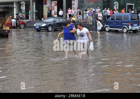 (140704) -- TAIYUAN, 4. Juli 2014 (Xinhua) -- Bürger gehen auf einer überfluteten Straße in Taiyuan, der Hauptstadt der nordchinesischen Provinz Shanxi, 4. Juli 2014. Am Freitag überfluteten Regenfälle die Straßen und verursachten Verkehrsunterbrechungen. (Xinhua/Zhan Yan) (mp) CHINA-SHANXI-TAIYUAN-RAININSTORM-FLOODS (CN) PUBLICATIONXNOTXINXCHN Taiyuan 4. Juli 2014 XINHUA-Bürger gehen AUF einer überfluteten Straße in Taiyuan Hauptstadt von Nordchina S Shanxi Provinz 4. Juli 2014 Regenfälle trafen die Stadt AM Freitag, überschwemmten Straßen und verursachten Verkehrsunterbrechungen XINHUA Zrainstoran China Shani MP Taiyuan YKN Stockfoto