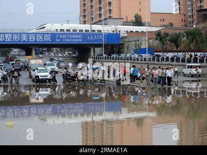 (140704) -- TAIYUAN, 4. Juli 2014 (Xinhua) -- Fahrzeuge und Fußgänger halten vor einem wasserdurchfluteten Abschnitt auf einer Straße in Taiyuan, der Hauptstadt der nordchinesischen Provinz Shanxi, am 4. Juli 2014. Am Freitag überfluteten Regenfälle die Straßen und verursachten Verkehrsunterbrechungen. (Xinhua/Yan Yan) (MP) CHINA-SHANXI-TAIYUAN-RAININSTORM-FLOODS (CN) PUBLICATIONxNOTxINxCHN TAIYUAN 4. Juli 2014 XINHUA FAHRZEUGE und Fußgänger halten vor einem wasserdurchfluteten Abschnitt AUF einer Straße in Taiyuan Hauptstadt VON Nordchina S Shanxi Provinz Juli 2014 Regenfälle in der Stadt AM Freitag Überschwemmungen Stockfoto