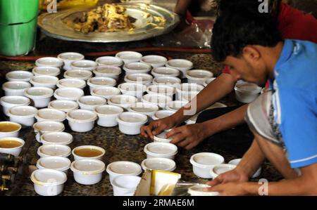 (140704) -- SANAA, 4. Juli 2014 (Xinhua) -- Ein jemenitischer Mann bereitet Mahlzeiten vor, die an die Armen in Sanaa, Jemen, am 4. Juli 2014 verteilt werden. Während des heiligen Monats Ramadan schenken Muslime den Armen, die ihre Familien nicht mit Essen versorgen können, wohltätige Hilfe, zum Beispiel kostenlose Nahrung. (Xinhua/Mohammed Mohammed) JEMEN-SANAA-RAMADAN-CHARITY PUBLICATIONxNOTxINxCHN SANAA 4. Juli 2014 XINHUA ein jemenitischer Mann bereitet Mahlzeiten zu, die an die armen Berühmtheiten in Sanaa verteilt werden Jemen 4. Juli 2014 während des Heiligen Monats Ramadan geben Muslime Charity zum Beispiel kostenloses Essen an die armen Berühmtheiten, die nicht unterstützen können Stockfoto