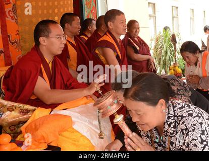 (140707) -- LHASA, July 7, 2014 (Xinhua) -- The 11th Panchen Lama Bainqen Erdini Qoigyijabu (1st L), who is also the vice president of the Buddhist Association of China (BAC) and a member of the Standing Committee of the Chinese People s Political Consultative Conference (CPPCC) National Committee, offers head-touching blessings to Buddhist believers in Lhasa, capital of southwest China s Tibet Autonomous Region, July 5, 2014. The Panchen Lama visited people from religious groups in Lhasa for the past few days, talking with them and offering head-touching blessings to Buddhist believers. (Xinh Stock Photo