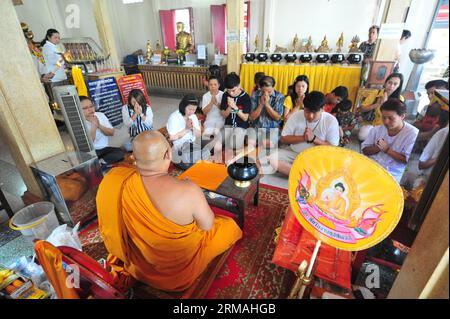 (140711) -- BANGKOK, 11. Juli 2014 (Xinhua) -- Thailändische Menschen beten in einem Tempel in Bangkok, Thailand, 11. Juli 2014. Thailändische Buddhisten im ganzen Land sind bereit, den buddhistischen Fastentag oder Khao Phansa zu feiern, der in diesem Jahr am 12. Juli stattfindet. Khao Phansa beginnt einen dreimonatigen Zeitraum, in dem buddhistische Mönche in ihren Tempeln leben, um zu studieren und zu meditieren. (Xinhua/Rachen Sageamsak) THAILAND-BANGKOK-BUDDHISTISCHE FASTTAG PUBLICATIONxNOTxINxCHN Bangkok 11. Juli 2014 XINHUA Thai Prominente BIETEN Gebete in einem Tempel in Bangkok Thai Land 11. Juli 2014 Thai Buddhisten quer durch den Grafen Stockfoto