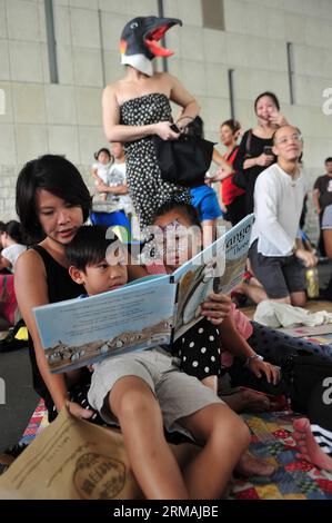 (140713) -- SINGAPUR, 13. Juli 2014 (Xinhua) -- Menschen besuchen eine Lesesitzung vor dem Gebäude der Nationalbibliothek in Singapur, 13. Juli 2014. Ein Minister der Regierung hat gesagt, dass sich das National Library Board of Singapore bei seiner jüngsten Entscheidung, drei Titel von Kindern über alternative Familien zurückzuziehen, von Gemeinschaftsnormen leiten ließ, berichteten lokale Medien am Samstag. (Xinhua/Then Chih Wey) SINGAPORE-CHILDREN S BOOK-KONTROVERSE PUBLICATIONxNOTxINxCHN Singapur 13. Juli 2014 XINHUA-Prominente nehmen an einer Lesesitzung vor dem National Library Building in Singapur Teil 13. Juli 2014 a Governn Stockfoto