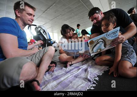 (140713) -- SINGAPUR, 13. Juli 2014 (Xinhua) -- Menschen besuchen eine Lesesitzung vor dem Gebäude der Nationalbibliothek in Singapur, 13. Juli 2014. Ein Minister der Regierung hat gesagt, dass sich das National Library Board of Singapore bei seiner jüngsten Entscheidung, drei Titel von Kindern über alternative Familien zurückzuziehen, von Gemeinschaftsnormen leiten ließ, berichteten lokale Medien am Samstag. (Xinhua/Then Chih Wey) SINGAPORE-CHILDREN S BOOK-KONTROVERSE PUBLICATIONxNOTxINxCHN Singapur 13. Juli 2014 XINHUA-Prominente nehmen an einer Lesesitzung vor dem National Library Building in Singapur Teil 13. Juli 2014 a Governn Stockfoto