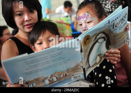 (140713) -- SINGAPUR, 13. Juli 2014 (Xinhua) -- Menschen besuchen eine Lesesitzung vor dem Gebäude der Nationalbibliothek in Singapur, 13. Juli 2014. Ein Minister der Regierung hat gesagt, dass sich das National Library Board of Singapore bei seiner jüngsten Entscheidung, drei Titel von Kindern über alternative Familien zurückzuziehen, von Gemeinschaftsnormen leiten ließ, berichteten lokale Medien am Samstag. (Xinhua/Then Chih Wey) SINGAPORE-CHILDREN S BOOK-KONTROVERSE PUBLICATIONxNOTxINxCHN Singapur 13. Juli 2014 XINHUA-Prominente nehmen an einer Lesesitzung vor dem National Library Building in Singapur Teil 13. Juli 2014 a Governn Stockfoto