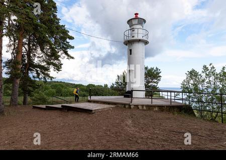 Junge Touristen mit Blick auf den Leuchtturm Rannapungerja am Ufer des Peipussees im Nordosten Estlands, an der Grenze zu Russland Stockfoto