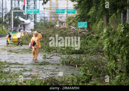 (140716) -- LAS PINAS CITY, 16. Juli 2014 (Xinhua) -- Eine Frau geht an Bäumen vorbei, die vom Taifun Rammasun in Las Pinas City, Philippinen, am 16. Juli 2014 entwurzelt wurden. Mindestens 5 Menschen wurden getötet, nachdem der Taifun Rammasun (lokaler Name: Glenda) am Mittwoch die philippinische Hauptstadt Metro Manila lahmlegte. (Xinhua/Rouelle Umali) PHILIPPINEN-LAS PINAS CITY-TAIFUN RAMMASUN PUBLICATIONxNOTxINxCHN Las Pinas CITY 16. Juli 2014 XINHUA eine Frau geht an Bäumen vorbei, die durch Taifun in Las Pinas City entwurzelt wurden die Philippinen 16. Juli 2014 mindestens 5 Prominente wurden nach dem Ansturm GETÖTET Stockfoto