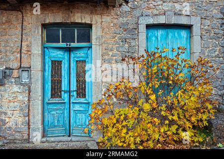 Altes und verlassenes Steinhaus mit bunten Doppeltür und Fenster, in dem malerischen Dorf Levidi, Arcadia Region, Peloponnes, Griechenland. Stockfoto
