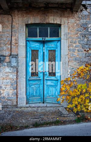 Altes und verlassenes Steinhaus mit bunten Doppeltür und Fenster, in dem malerischen Dorf Levidi, Arcadia Region, Peloponnes, Griechenland. Stockfoto