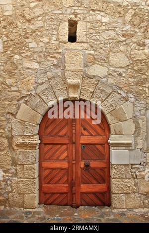 Wunderschöne alte traditionelle Tür mit kunstvollem Steinbogen-förmigen Sturz, in dem malerischen Dorf Margarites, in der Region Rethymno, Kreta, Griechenland Stockfoto