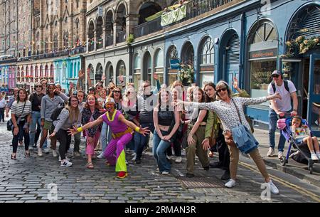 Grassmarket, Edinburgh, Schottland, Großbritannien. 27. August 2023. Die stille Disco unter der Leitung von David für Guru Dudu führt durch Grassmarket und in die Victoria Street im Stadtzentrum. Diese häufigen Veranstaltungen wurden von einigen Einheimischen negativ kommentiert, da die Teilnehmer oft die Lieder auf ihren Kopfhörern laut auf ihren Stimmen singen, andere Passanten sich über die Szene amüsieren. Quelle: Archwhite/Alamy Live News. Stockfoto