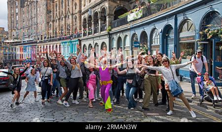 Grassmarket, Edinburgh, Schottland, Großbritannien. 27. August 2023. Die stille Disco unter der Leitung von David für Guru Dudu führt durch Grassmarket und in die Victoria Street im Stadtzentrum. Diese häufigen Veranstaltungen wurden von einigen Einheimischen negativ kommentiert, da die Teilnehmer oft die Lieder auf ihren Kopfhörern laut auf ihren Stimmen singen, andere Passanten sich über die Szene amüsieren. Quelle: Archwhite/Alamy Live News. Stockfoto