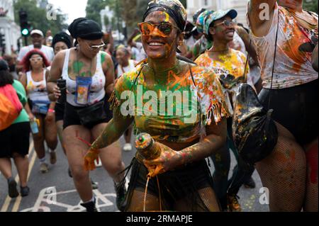 Am 27. August 2023 feiern hunderttausende von Feiernden den ersten Tag des Karnevals in Notting Hill, West London, England, indem sie farbige Pers werfen Stockfoto