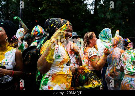 Am 27. August 2023 feiern hunderttausende von Feiernden den ersten Tag des Karnevals in Notting Hill, West London, England, indem sie farbige Pers werfen Stockfoto