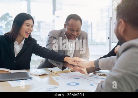 Unterschiedliche Geschäftsleute sind sich einig zwischen Geschäftsleuten, und ihre Hände sind für Projektentwicklung und Innovation übereinander gestapelt Stockfoto