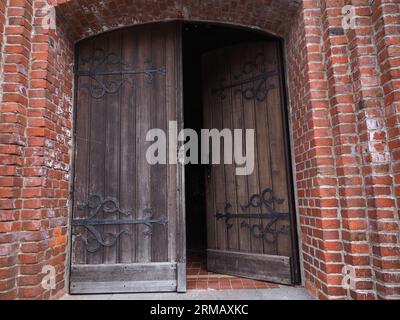 Eingangstür einer alten Kirche aus Ziegeln Stockfoto