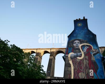 Gemaltes Wandgemälde an der Seite eines Gebäudes in der Nähe des Viadukts in Morlaix, Bretagne, Frankreich. Stockfoto