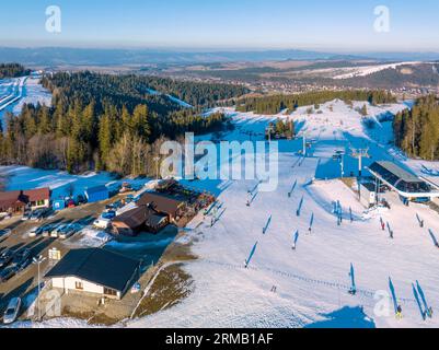 Skipiste, Sessellift, Skifahrer und Snowboarder im Skigebiet Bialka Tatrzanska in Polen auf dem Berg Jankulakowski Wierch im Winter. Luftaufnahme in der Sonne Stockfoto