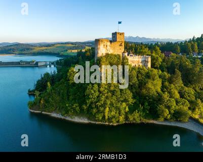 Polen. Mittelalterliche Burg in Niedzica, 14. Jahrhundert (oberer Teil) bei Sonnenuntergang. Künstlicher Zarensee am Dunajec-Fluss, verdammt und Wasserkraftwerk Stockfoto