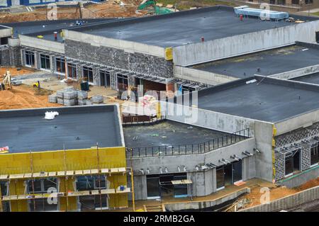 Bau eines einstöckigen, komfortablen, modernen, monolithischen Rahmengebäudes eines Einkaufszentrums in Gehweite in einer neuen Gegend. Blick von ABO Stockfoto