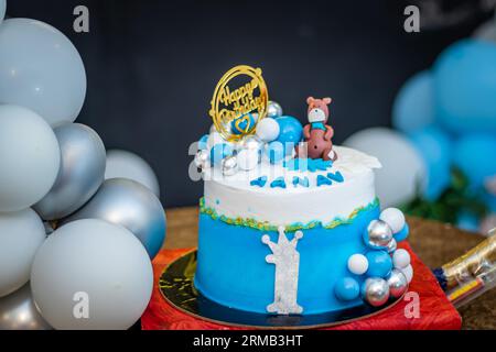 Isolierter einjähriger Geburtstagskuchen mit weißen und blauen Ballons aus verschiedenen Blickwinkeln Stockfoto