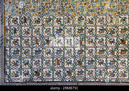 Maurische Ziegelwand aus dem 14. Jahrhundert in den Gärten des königlichen Alcazar-Palastes mit Bildern von mythischen Kreaturen, Sevilla, Andalusien, Spanien Stockfoto