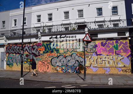 London, Großbritannien. 27. August 2023. Eine Frau geht an geschlossenen und bewachten Geschäften vorbei, als der Notting Hill Carnival 2023 beginnt. (Foto: Vuk Valcic/SOPA Images/SIPA USA) Credit: SIPA USA/Alamy Live News Stockfoto