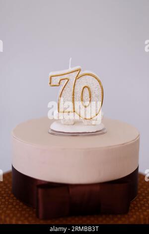 Detail der Zahl siebzig oben auf dem Geburtstagskuchen, 70 Geburtstag, weißer Kuchen, 70 Jahre alte Geburtstagskuchen Kerze Stockfoto