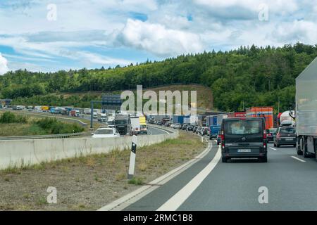 Deutschland - 1. August 2023: Verkehr auf der Autobahn A3 und Lastkraftwagen, die in einer langen Warteschlange warten. Stockfoto