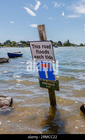 Beachten Sie: „Diese Straße überflutet jede Flut“, Shore Road, Bosham, ein Küstendorf in Chichester Harbour an der Südküste, West Sussex bei Flut Stockfoto