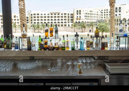 Bar mit Flaschen von bekannten Marken von Alkohol, Brillenständer. Hintergrund arabischer Architektur Stockfoto