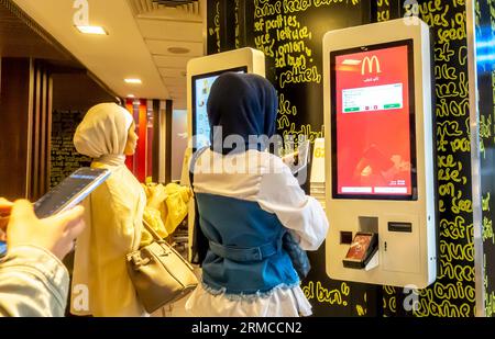 Kunden vor McDonald's Digital Menu Boards, elektronisches Menü McDonalds, digitales Menü von McDonald's in Aqaba McDonalds Jordan Stockfoto