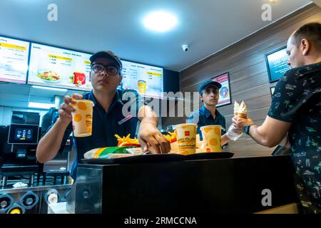 Männlicher Mitarbeiter, der McDonalds-Bestellung im McDonalds Aqaba Restaurant Jordanien liefert Stockfoto