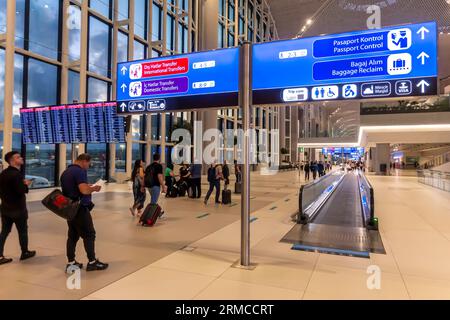 Passagiere vor Richtungsschildern - Passkontrolle, Gepäckausgabe, am Flughafen Istanbul Havalimani - ist Airport Inside, Türkei Stockfoto