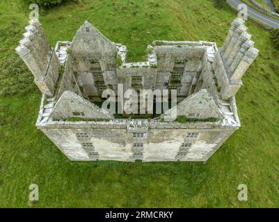 Luftaufnahme der Burg Glinsk mittelalterliches befestigtes Turmhaus in Irland mit symmetrischer Struktur fünf lange hohe Schornsteine auf jeder Seite, County Calway Stockfoto