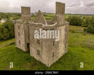 Luftaufnahme der Burg Glinsk mittelalterliches befestigtes Turmhaus in Irland mit symmetrischer Struktur fünf lange hohe Schornsteine auf jeder Seite, County Calway Stockfoto