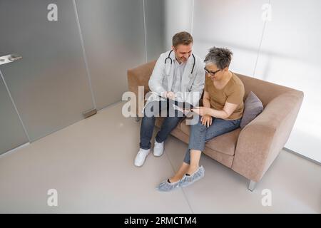 Arzt erklärt Röntgenresultat für Patientin in der Klinikpraxis. Gesundheitskonzept Stockfoto